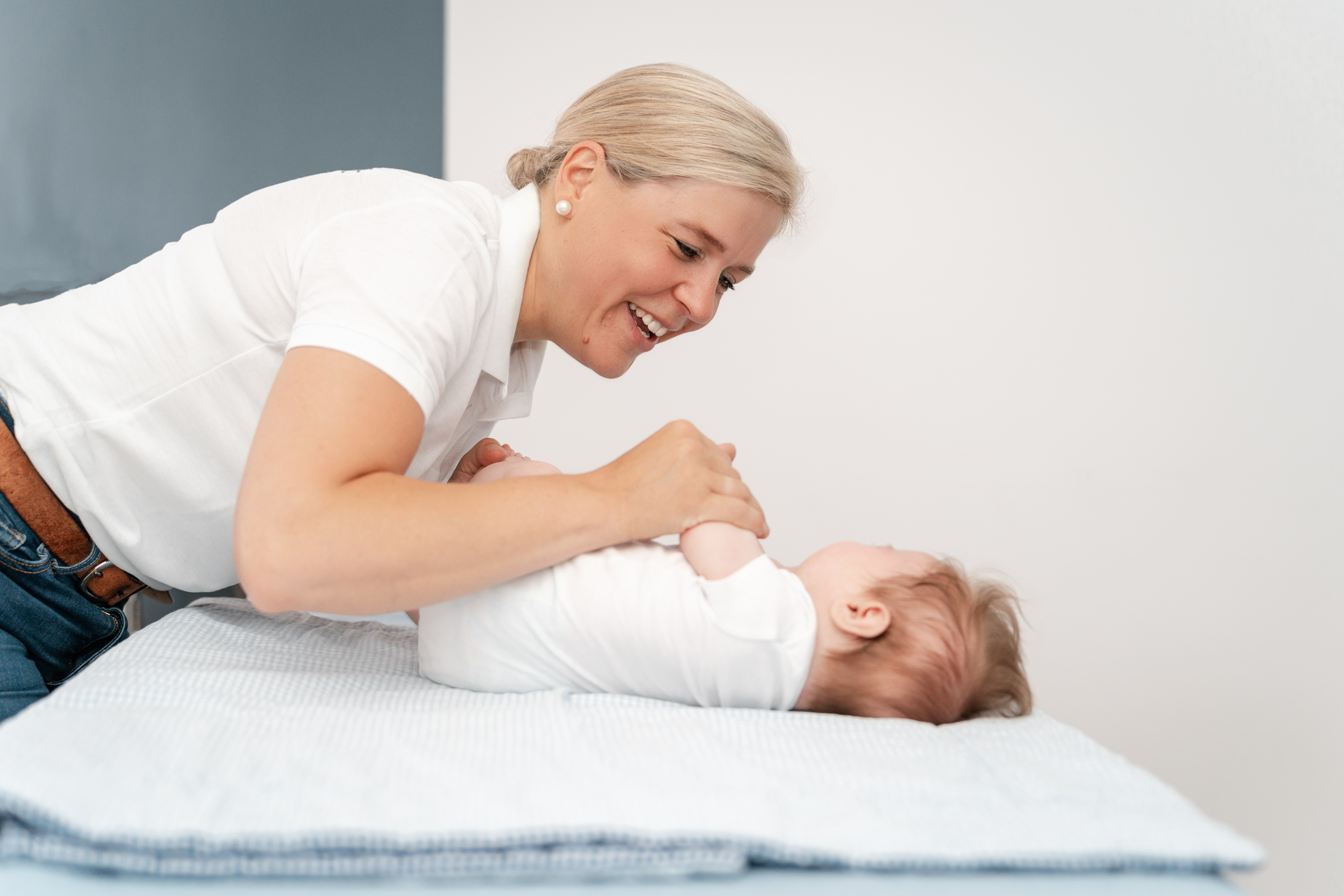 Therapeutin und Säugling bei einer begleiteten Bewegungsübung