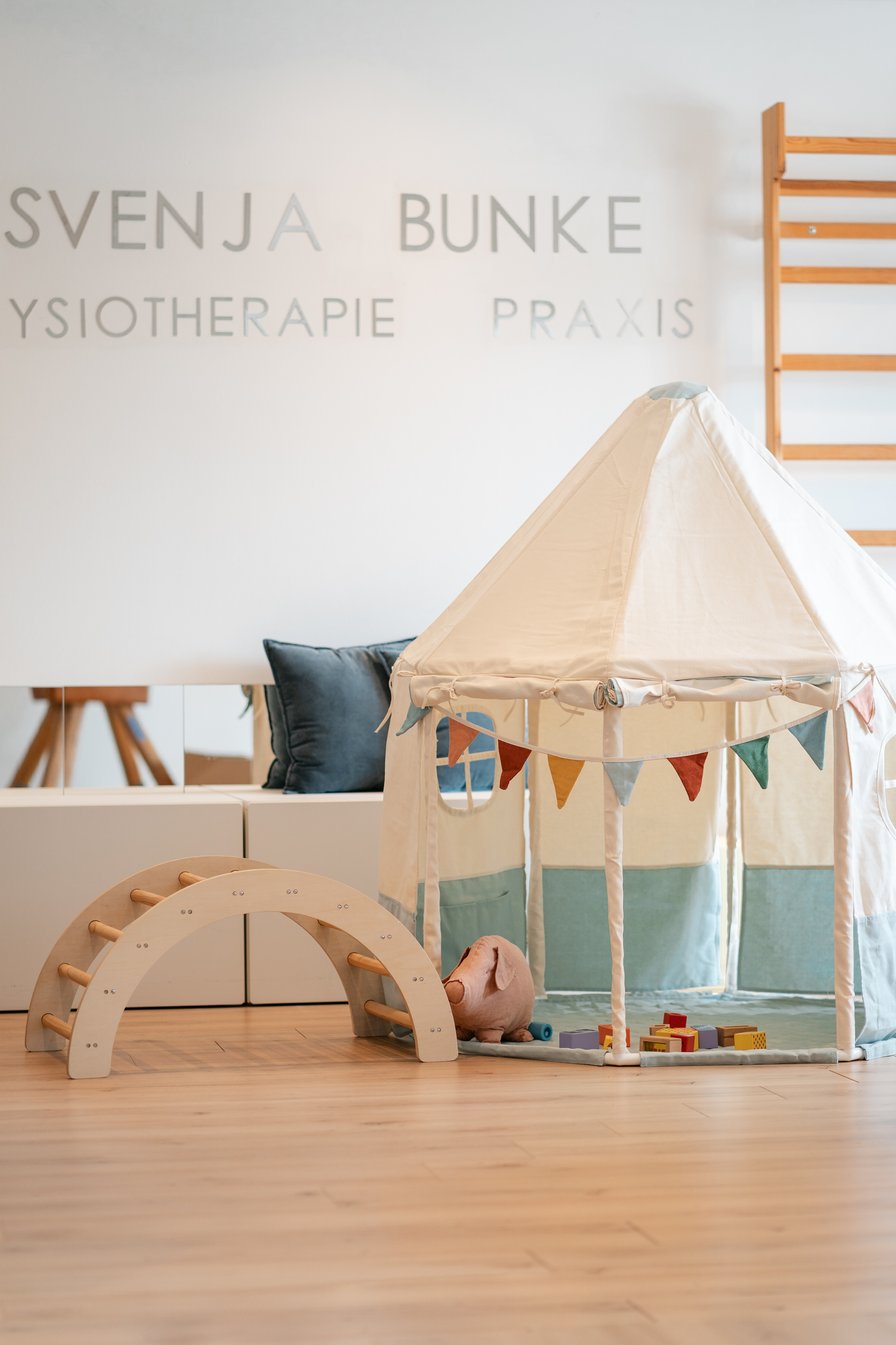 Kindgerechter Therapieraum mit Spielzelt, Kletterbogen und weichen Kissen