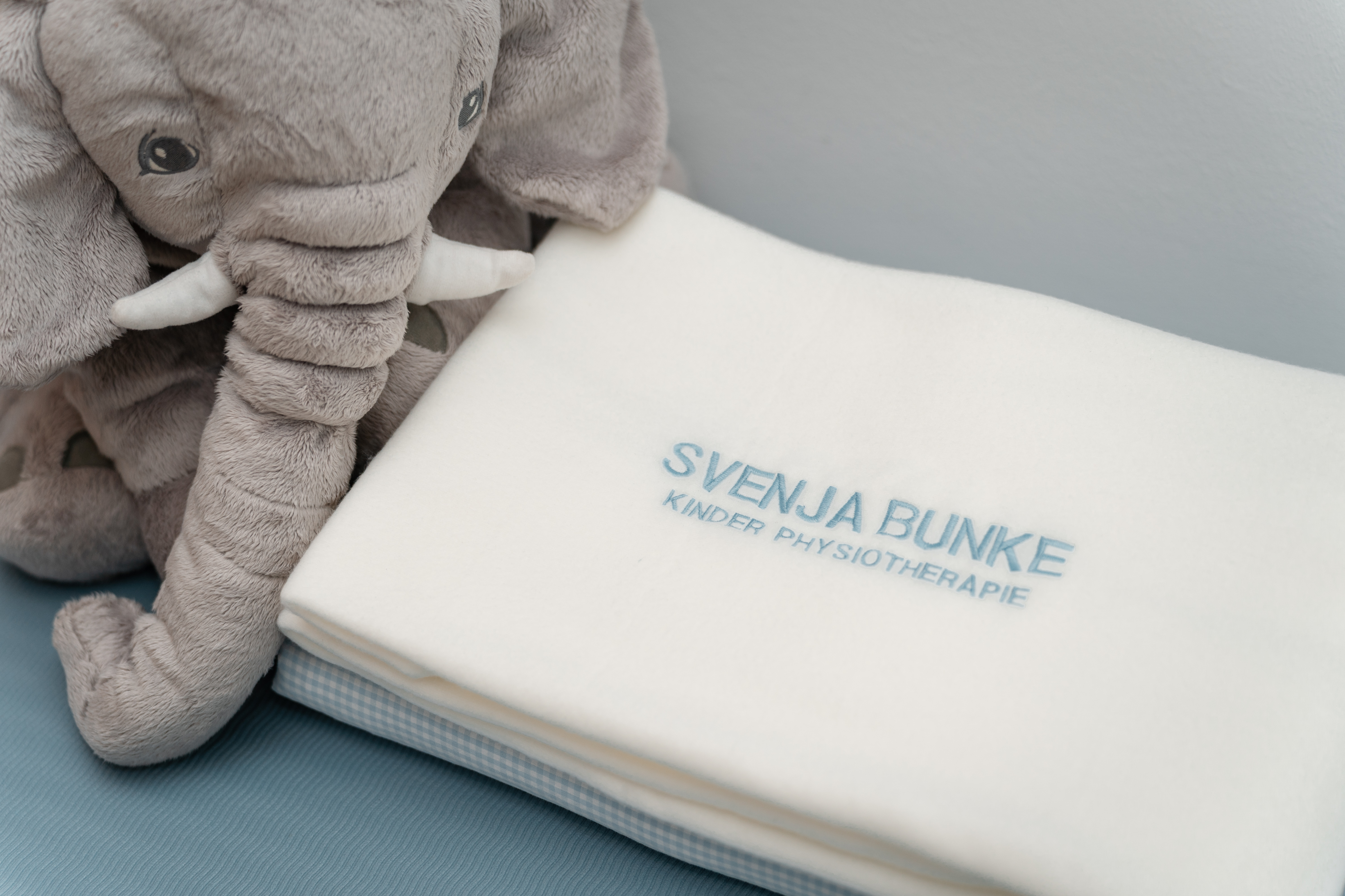 Kuschelelefant und Decke mit dem Schriftzug Svenja Bunke Kinderphysiotherapie